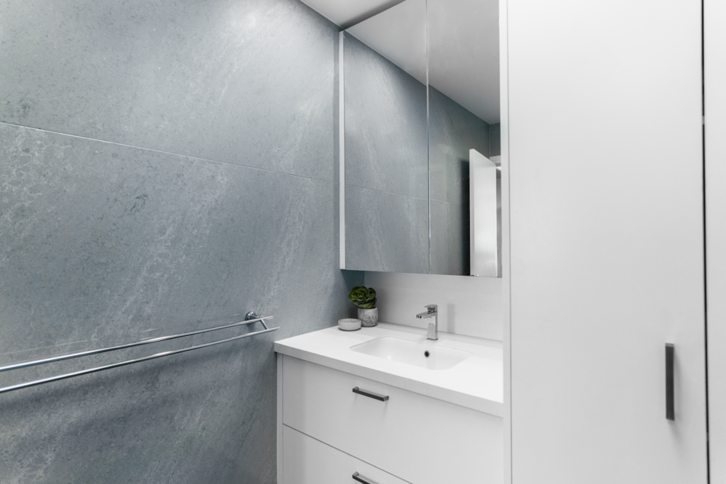 StoneCraft Kitchen & Bath | Lisa's Bathroom (Mount Cemento) We had the pleasure of transforming Lisa's modest half bath into a tranquil haven of relaxation and style. Drawing inspiration from soothing soft blue tones, we curated a calming ambiance that resonated with a sense of serenity. The carefully selected Mount Cemento stone played a pivotal role in shaping the space, enveloping the walls and the shower in an understated yet striking elegance.